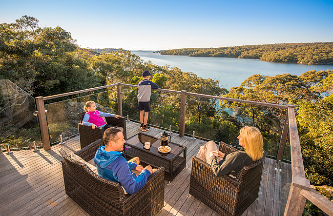 A family relax on the balcony of Hilltop Cottage, Royal National Park. Photo: J Spencer/OEH.
