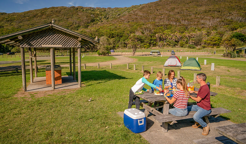 A family having a picnic at The Ruins campground, Booti Booti National Park. Credit: John Spencer &copy; DPIE