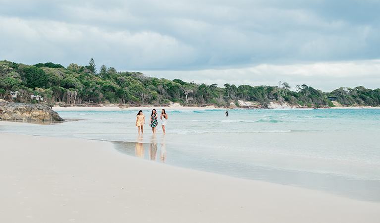 3 friends walking on the beach near Thomson Cottage. Photo: Sera Wright &copy; DPIE